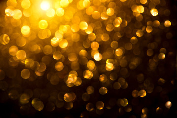 Christmas golden glowing background. Holiday abstract defocused backdrop. Tinsel blurred gold bokeh...