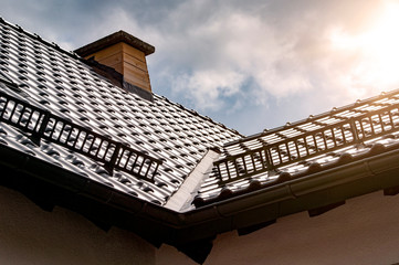 Dachfläche mit Kamin und Schneefang im Sonnenlicht