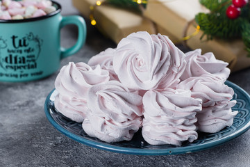 Delicious christmas dessert with festive decoration. Homemade marshmallow or zephyr on plate and mug of hot chocolate with marshmallow on gray table