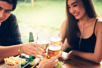 Young asian people having fun at drinking with cheering with beer at restaurant.