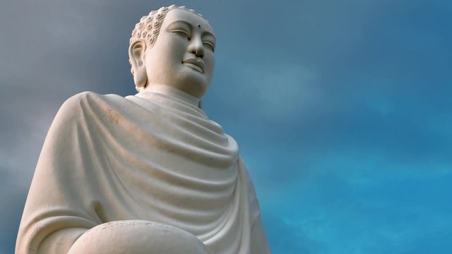 Gautama buddha sculpture on the cloud sky background sunset time lapse