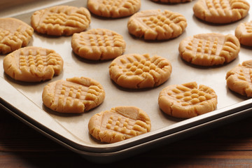 Peanut butter cookie dough on baking sheet in natural kitchen light.