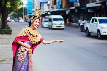 Thai models in Thai dance Smiling and call for passenger cars. On the road in Bangkok in the morning.
