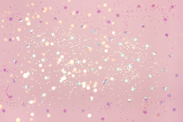 Delicate pink Christmas background with beautiful pink confetti on. Top view. Copy space for your design.