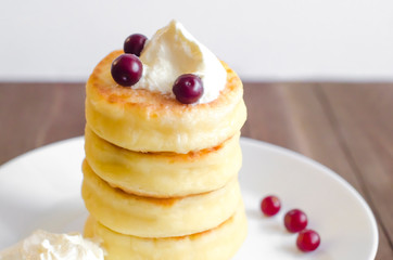 Cottage cheese pancakes with sour cream and berries on rustic background. Syrniki. Russian food. Copy space