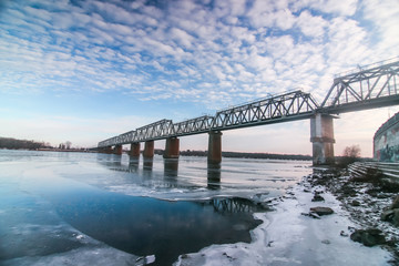 Fototapeta na wymiar Railway bridge across Dnipro with beautiful cloudy sky in Kyiv, Ukraine
