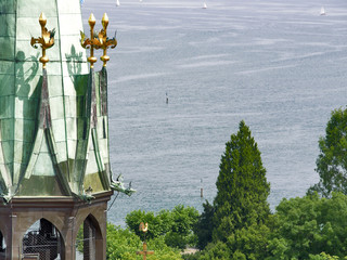 Kirchturm Konstanzer Münster mit Seglern auf Bodensee im Hintergrund
