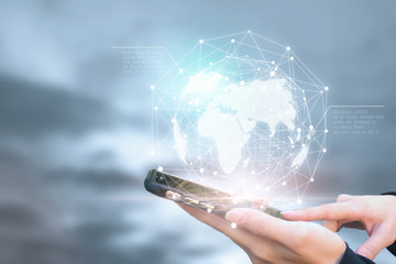 Businessman holding phone in hand with global connection concept.