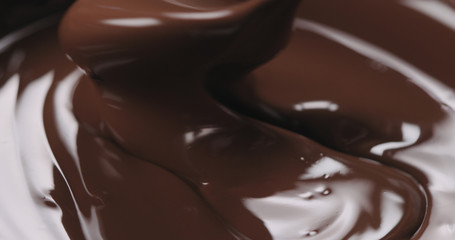 closeup stirring melted dark chocolate with spoon
