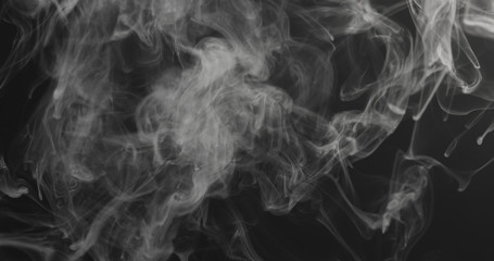 closeup vapor rises from bottom on black background