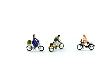 Miniature people : man and friend ride bicycle on white background.