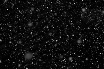 Falling snow isolated on black