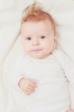 Happy child on the white blanket, soft focus background
