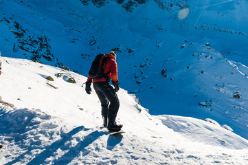 Chamonix de Mont Blanc, France, December 24, 2015. A snowboarder wearing a bright red vest...