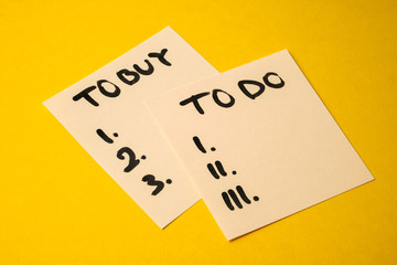 Concept tasks for the day what to buy and do. Yellowish stickers with inscriptions on a yellow background.