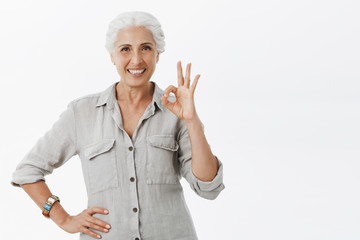 Old happy lady assuring her money in safe place thanks to bank. Portrait of pleased confident and...