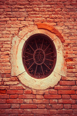 A small rusty window of circular shape.