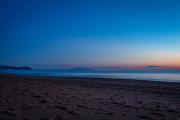 Sunset on the edge of the sea. The sky is illuminated with warm colors.