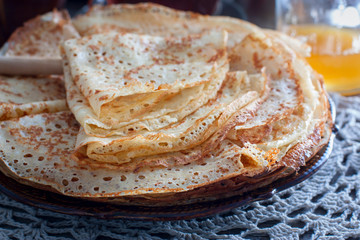 Fishnet thin pancakes on the table with a napkin, horizontal
