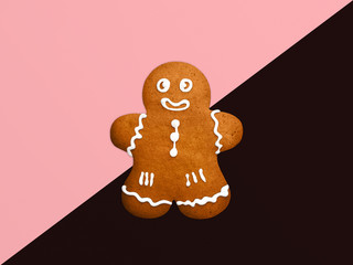 Classic Christmas cookieTop view photo Gingerbread man is lying on a two-tone background Template with copy space