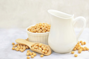 Soybean milk on dry soya beans background, vegan protein legumes for healthy vegetarian diet, selective focus