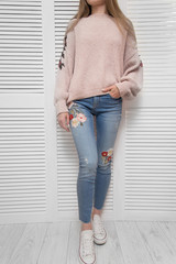 Girl in sweater and jeans on white background