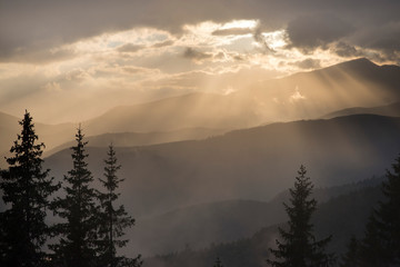 Sun rays passing trough clouds in the mountains