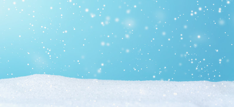 Snowfall over blue sky in a snow covered landscape