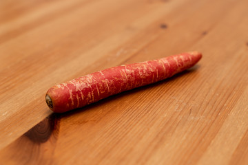 A red carrot on a wooden table