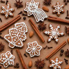Christmas dekoration with spices and cookies in the shape of snowflakes, cinnamon sticks and star anise on dark brown paper background. Top view.