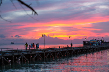 Suratthani, Thailand - November 15, 2018: People are exercising on the bridge, the harbor, the evening, the bright sky, and many fishing boats on the November 15, 2018 in Samui Island, Suratthani, Tha