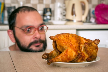 Funny hungry man looking on the chicken
