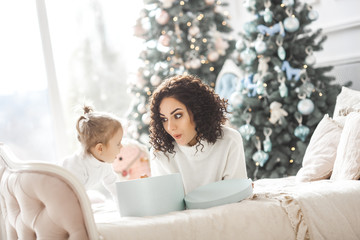 Young mother with her baby on Christmas background