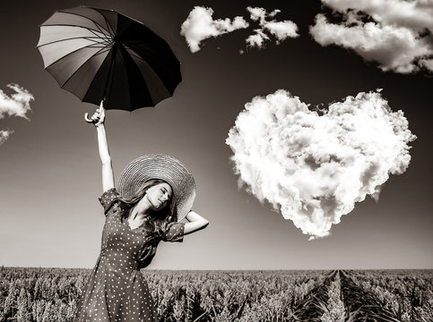Girl with umbrella at corn field with heart shape clouds. Image in black and white color style