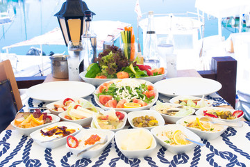 Seafoods, fish, salad and mezes on the table near the sea