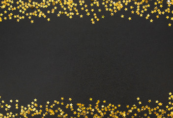 Frame of Golden stars scattered on black background