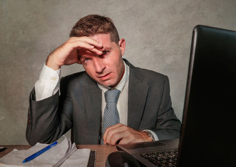 young stressed and overwhelmed businessman in suit and tie working at office laptop computer desk...