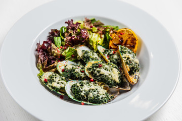 Mussels, baked with spinach and cheese, with salad and lemon