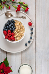 Breakfast, oatmeal with blueberry and raspberry on white bowl. Healthy food