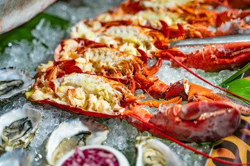 Beautiful tasty lobsters on ice ready to eat. Seafood large lobsters, some oysters on ice in a restaurant. Close-up