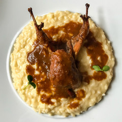 Typical north italy, lombardy dish: risotto alla prmigiana with roasted quail