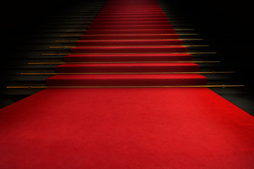 Red carpet on the stairs on a dark background. The path to glory, victory and success - obrazy, fototapety, plakaty