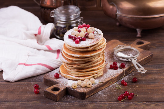 American pancakes with fresh berries on wooden background