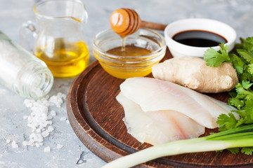 Raw white fish, ginger, herbs and condiments for cooking