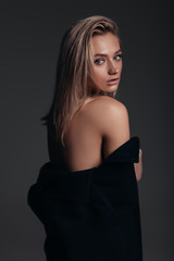 Naklejka premium Fashion model with a nude make-up, dark background, stylish girl