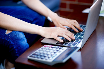 Hand and computer of the girl doing business online. Business concept with copy space