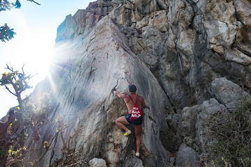 Sportler mit Rucksack klettert auf einen Fels