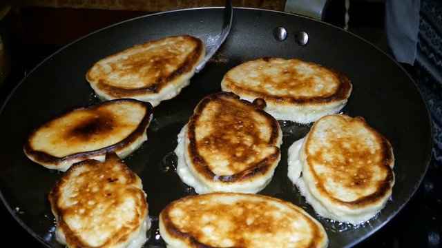 Homemade baking. Cooking fried fresh delicious pancakes in a pan in boiling oil. Pancakes - a traditional breakfast in Russian, Ukrainian cuisine and kitchen of other nations of the world.