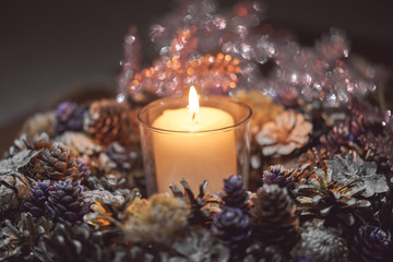 Advent decoration, wreath, candle. In the dark a candle in a beautiful decorative wreath is burning.