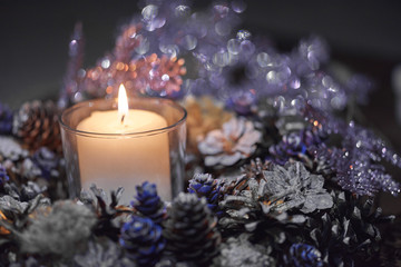 Advent decoration, wreath, candle. In the dark a candle in a beautiful decorative wreath is burning.
